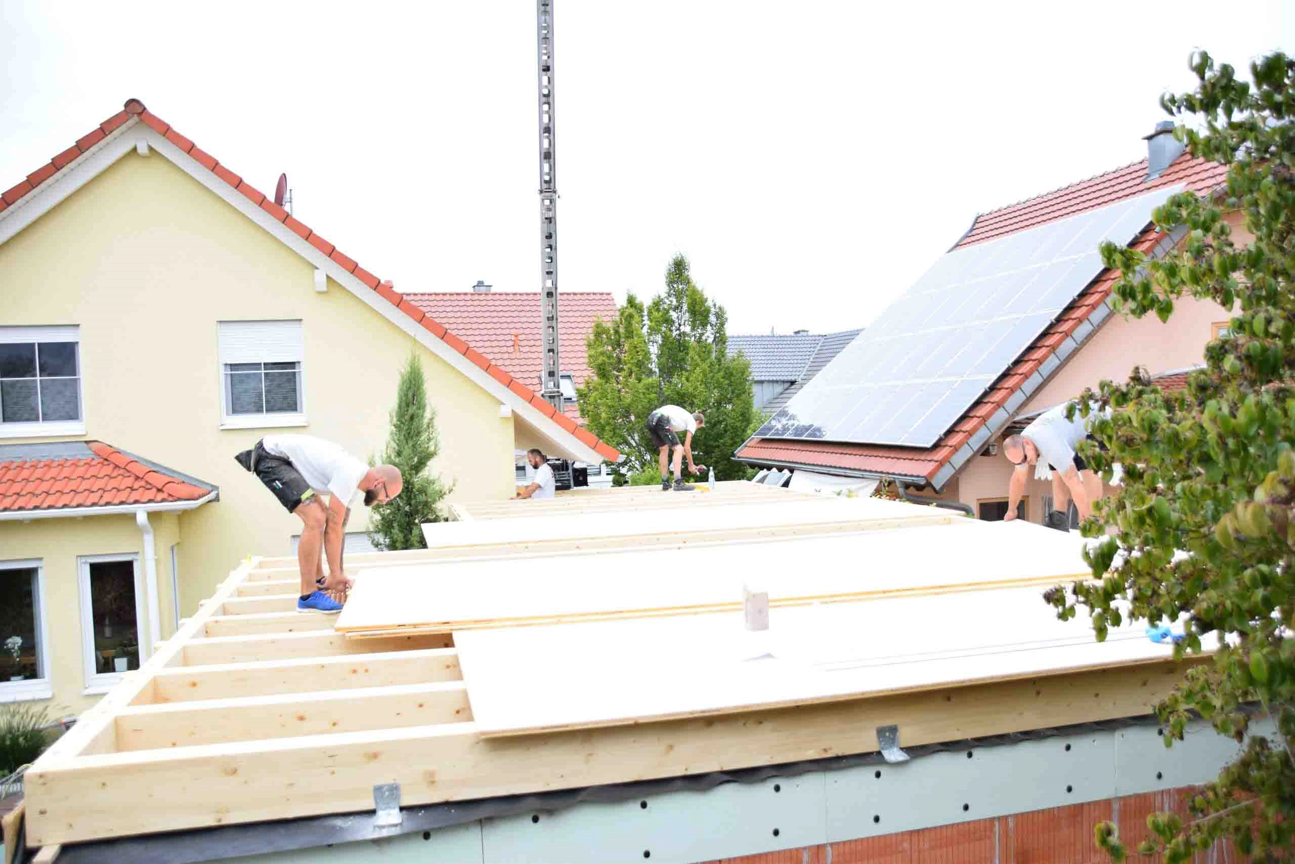 Mitarbeiter auf einem neuen Holzdach gebaut von der Zimmerei Dörr
